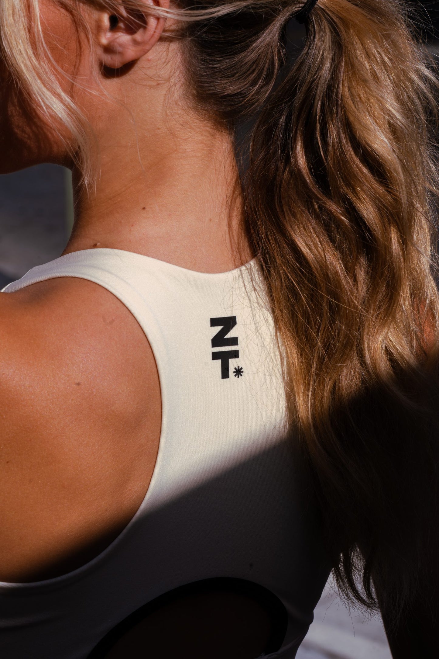 Close-up of a woman's shoulder and neck in the bone CTRL Sports Bra.