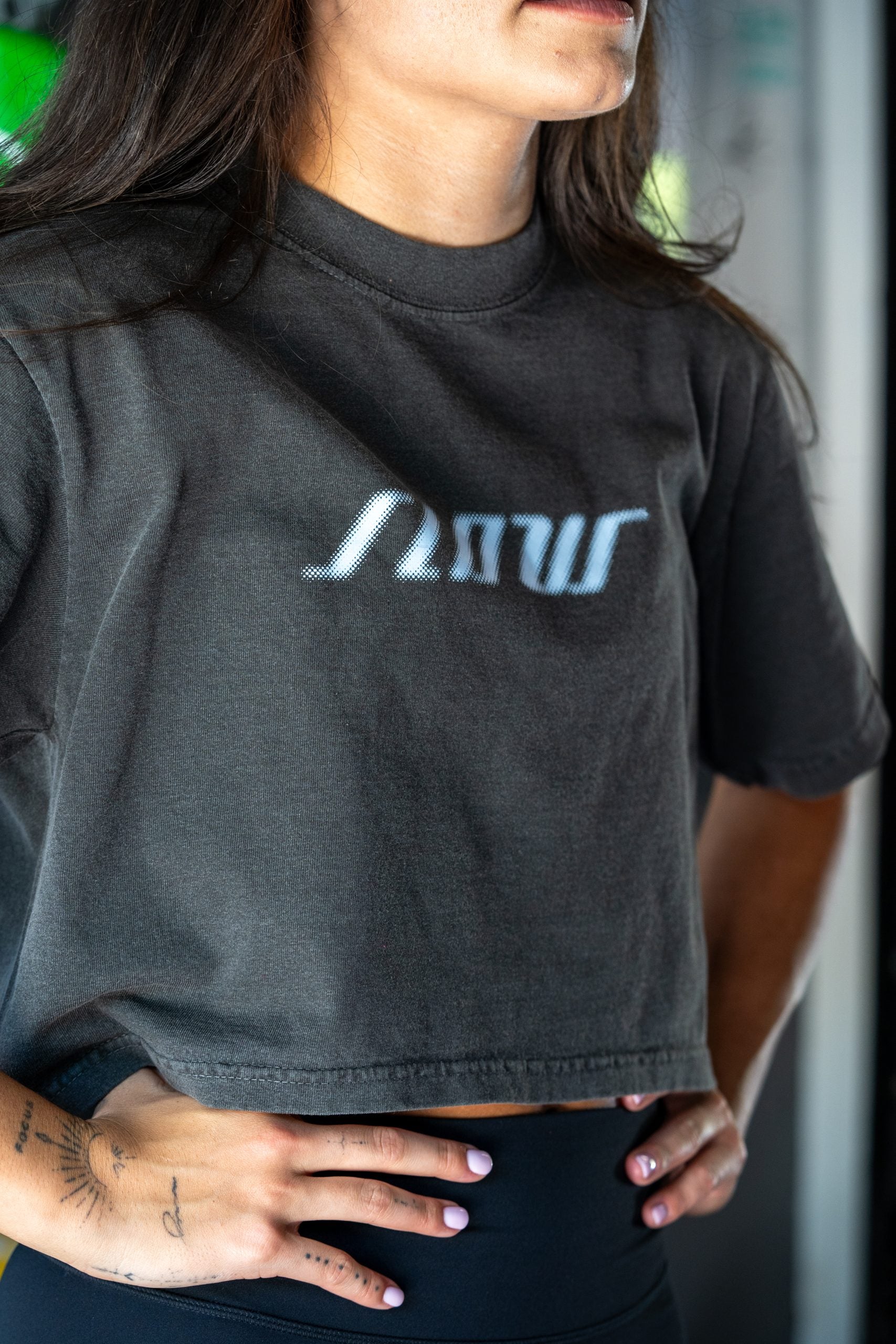 A woman in the charcoal Slow Crop with SLOW printed across the chest.