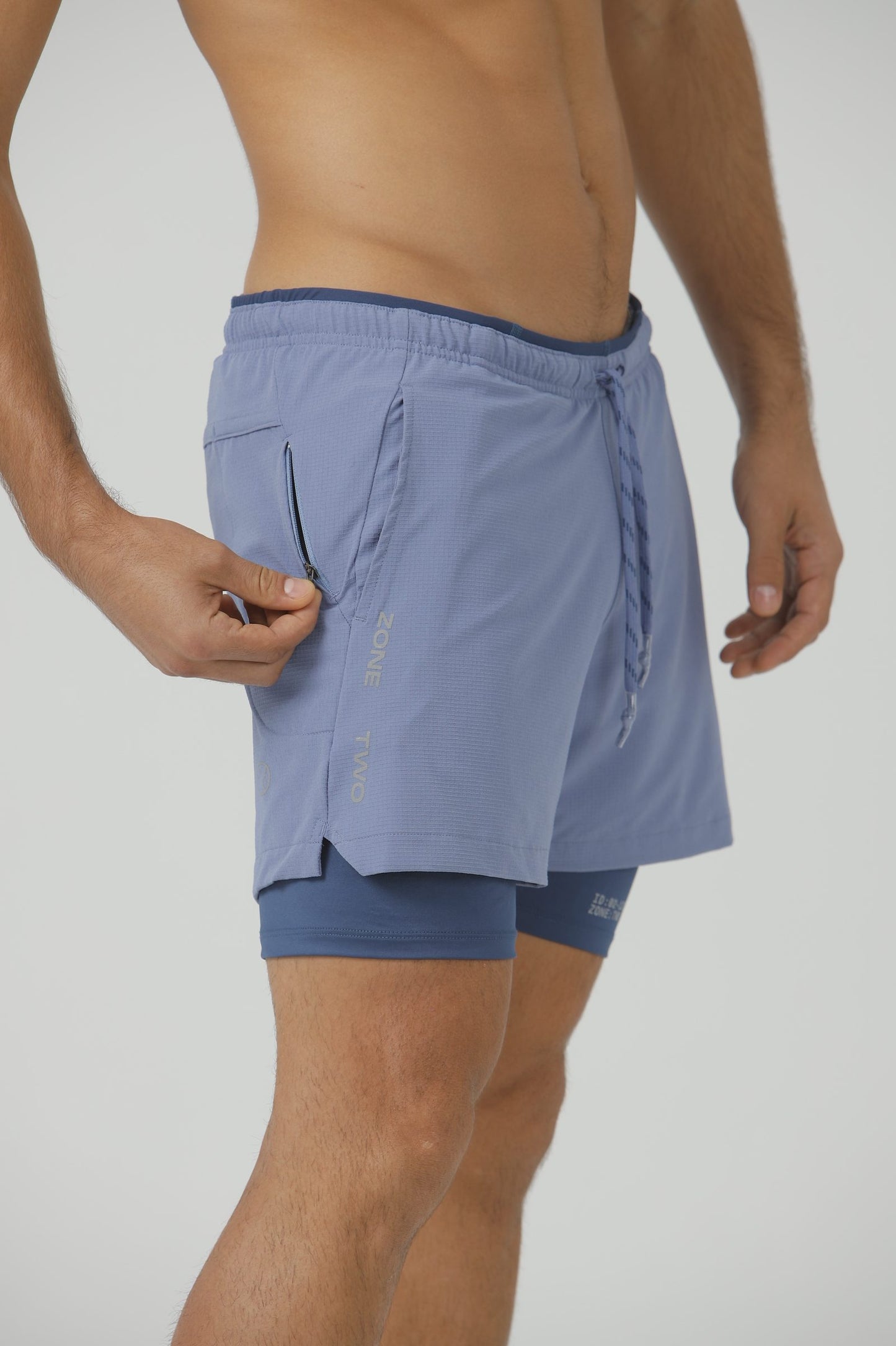 Close-up of the Blue Mirage Drift Shorts with a hand at the zip hip pocket.